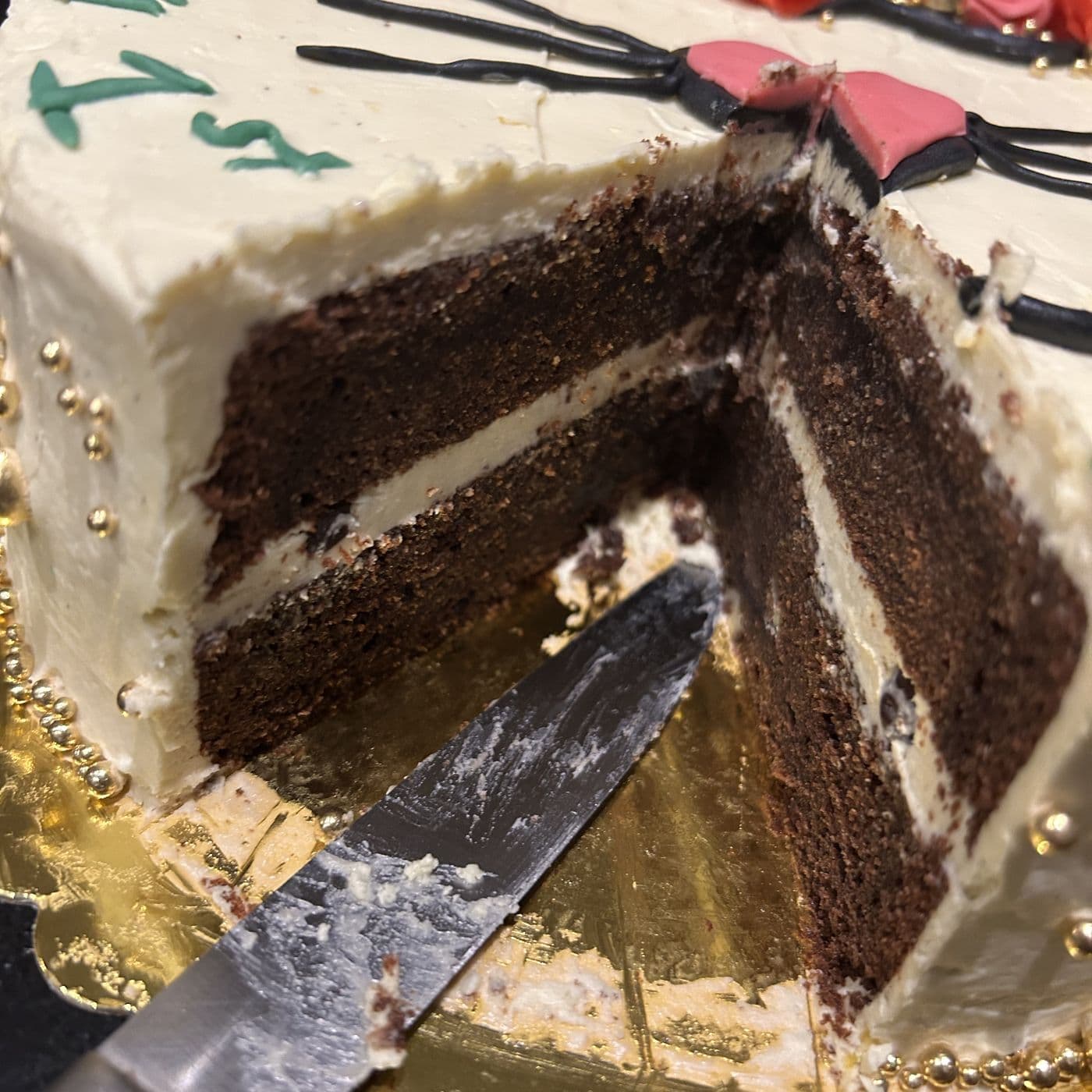 The same birthday cake cut open, showing three layers of chocolate sponge filled with vanilla buttercream