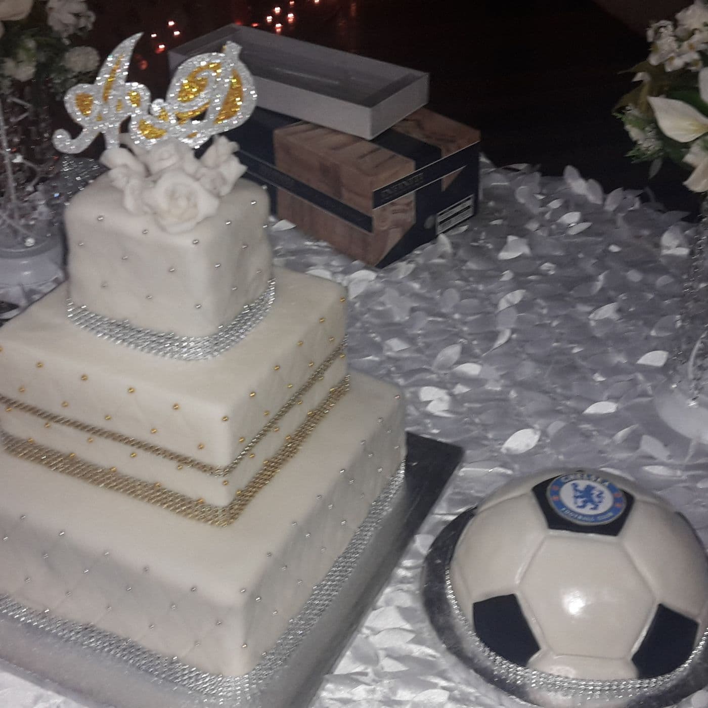 A tiered wedding cake in smooth white icing on a display table
